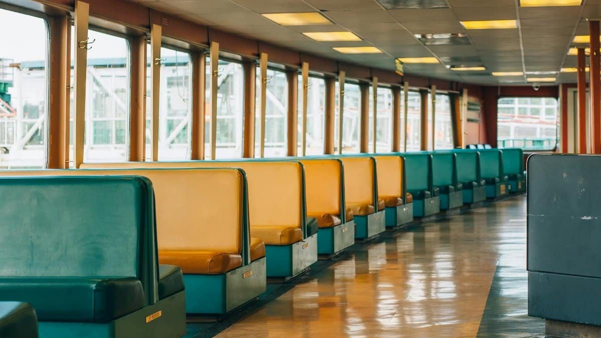 Interior view of Seattle ferry with colorful yellow and green seats, showcasing travel atmosphere.