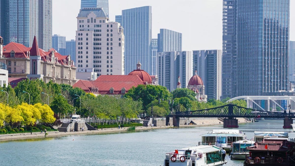 Modern skyline with river view and boats, showcasing a serene urban environment.