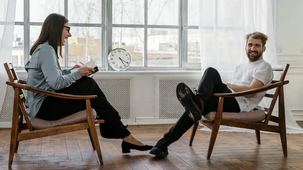 Counselor and client in a positive therapy session in a well-lit room.