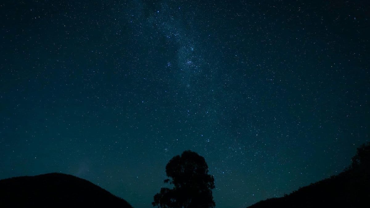 A captivating starry sky with Milky Way and silhouette of landscape in Somerset Dam, Australia.