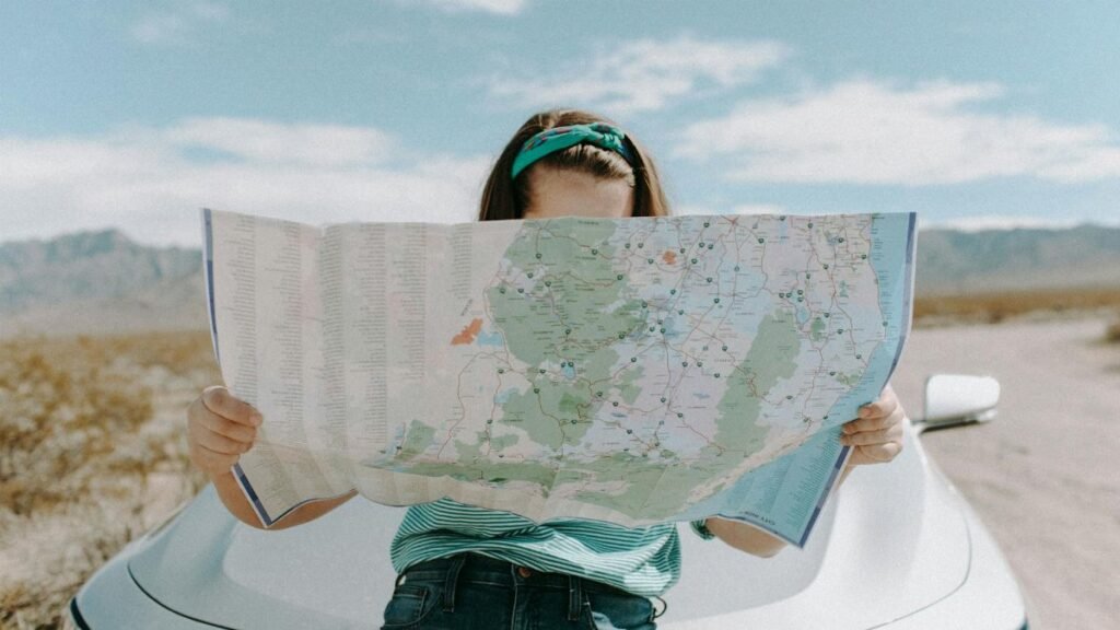 A woman holds a map while traveling through the scenic desert of California, USA.
