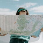A woman holds a map while traveling through the scenic desert of California, USA.