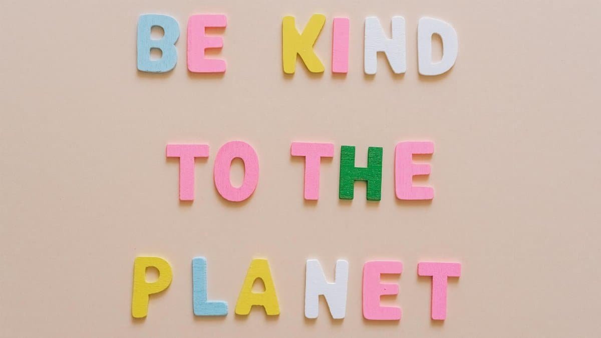 Colorful letters spelling 'Be Kind to the Planet' on a beige background.