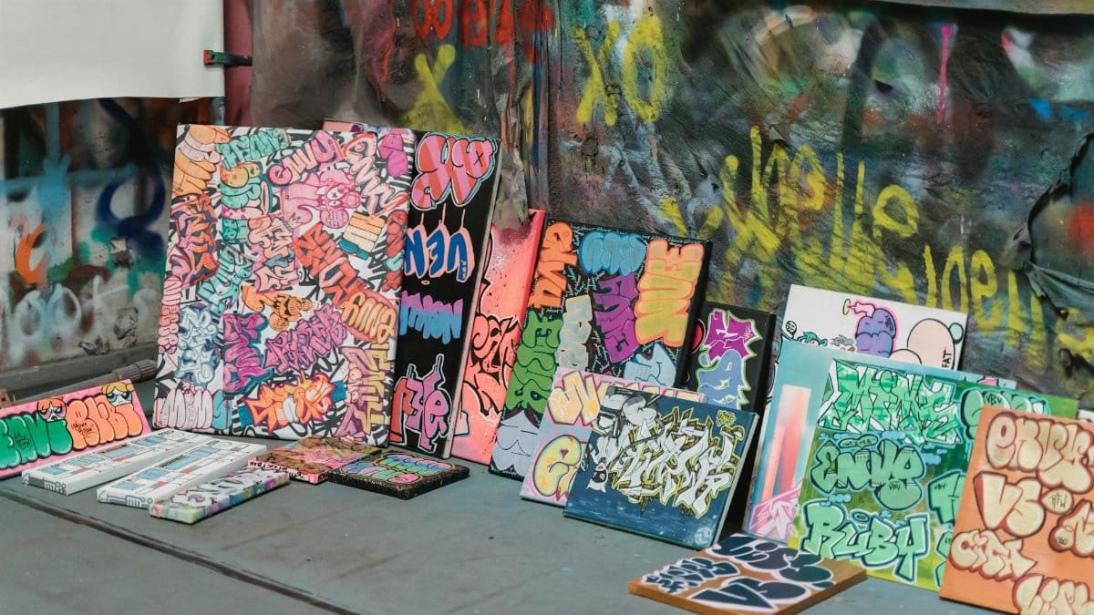 Vibrant graffiti art canvases arranged in an urban studio setting.