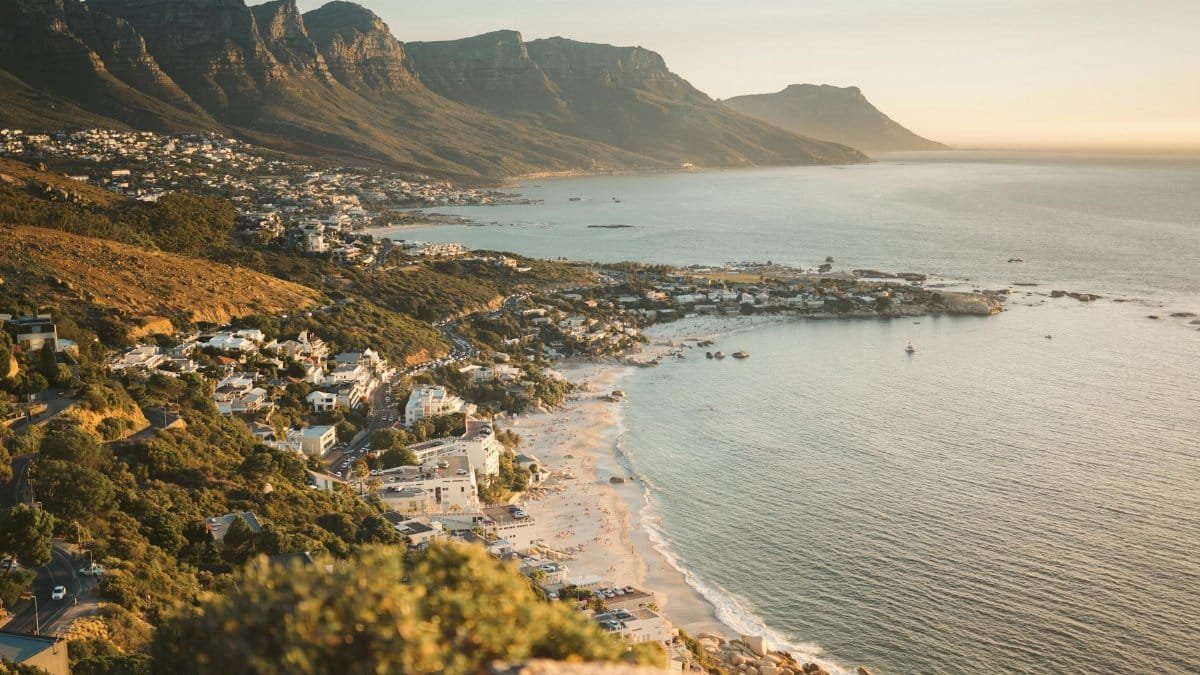 Explore Cape Town's stunning coastline with mountains and beaches, captured at sunset.