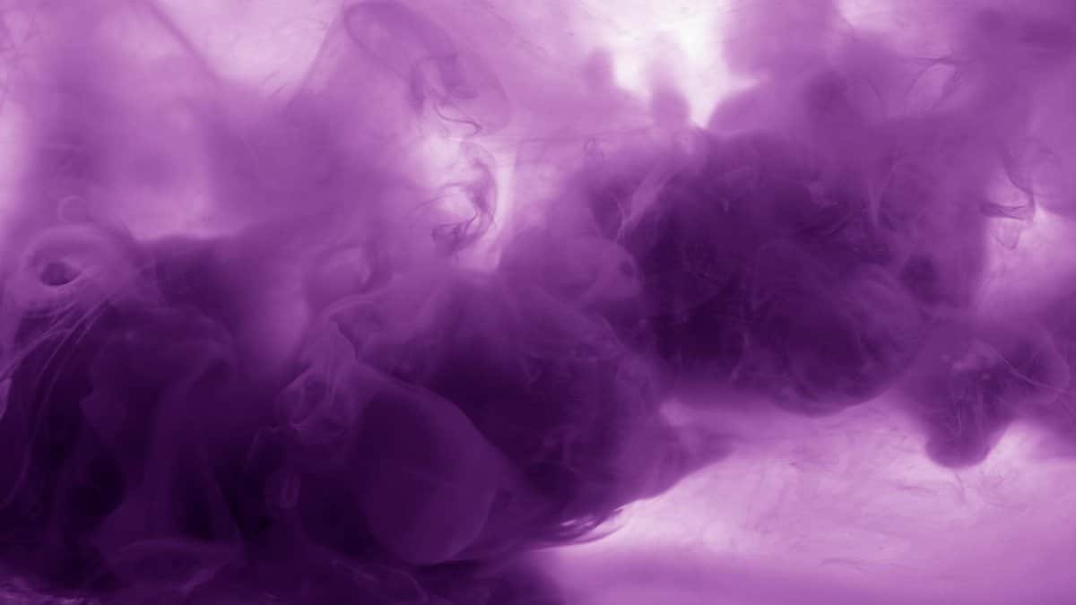 Vibrant purple smoke texture with flowing abstract patterns, perfect for creative backgrounds.