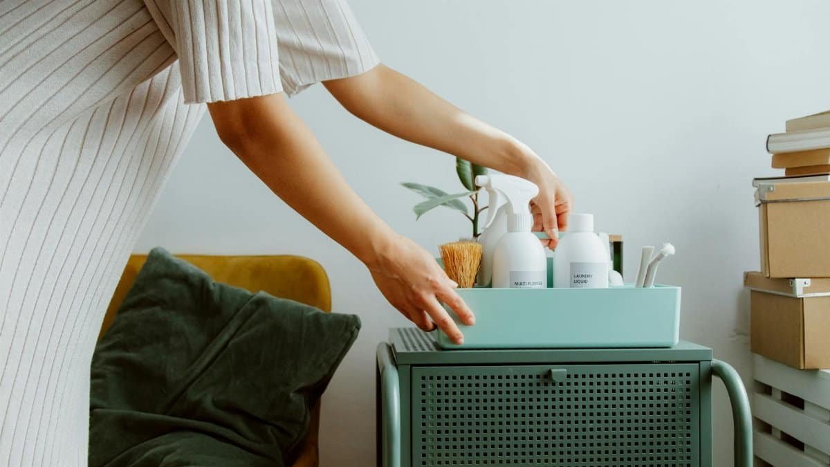 A woman organizes self-care products in a stylish room, embodying minimalism and tranquility.
