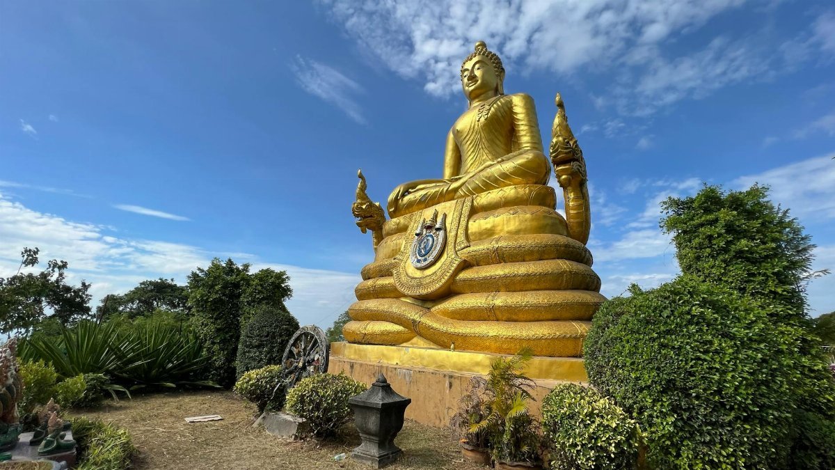 Stunning golden Buddha statue under a blue sky in Phuket, Thailand. Ideal for travel or cultural themes.