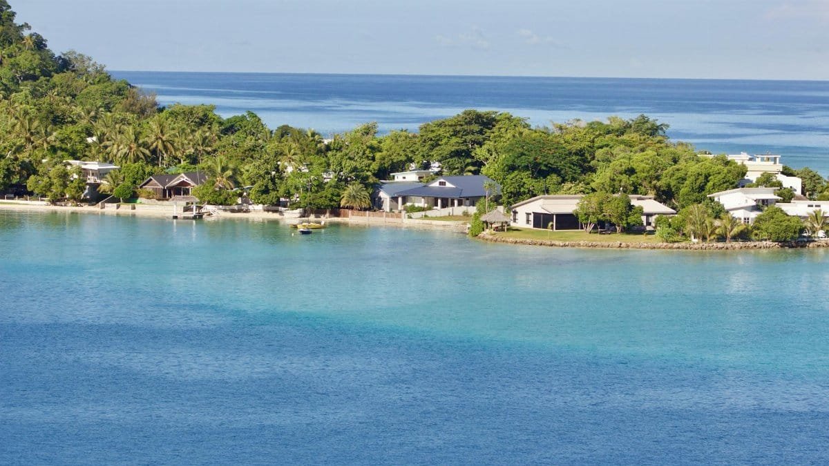 Scenic view of a tropical island resort with clear blue waters and lush greenery, ideal for vacations.