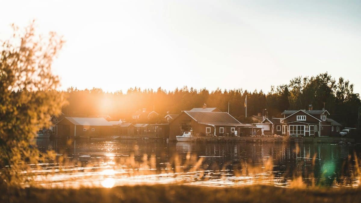 Peaceful lakeside cabins at sunset, capturing Scandinavian tranquility and nature's beauty.