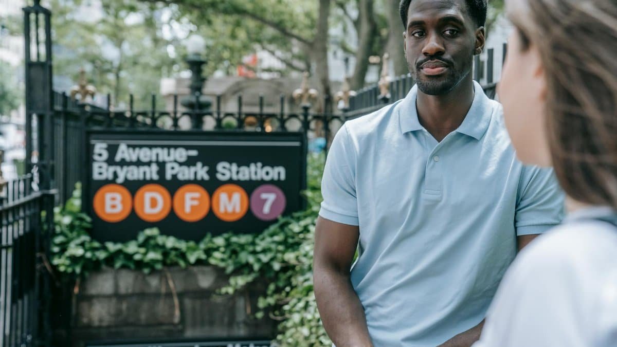 Two people chatting near 5 Avenue-Bryant Park subway entrance in NYC.
