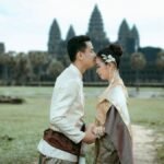 A couple in traditional Cambodian attire embracing at Angkor Wat, a symbol of timeless love.