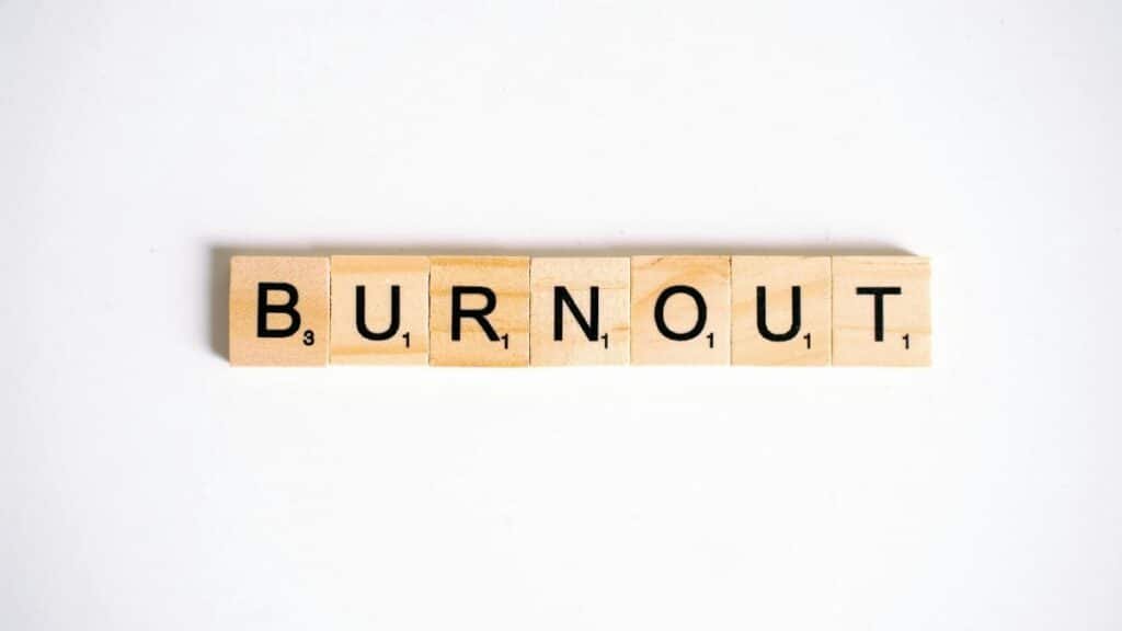 Conceptual image of 'Burnout' spelled with Scrabble tiles on a white background.