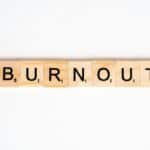 Conceptual image of 'Burnout' spelled with Scrabble tiles on a white background.