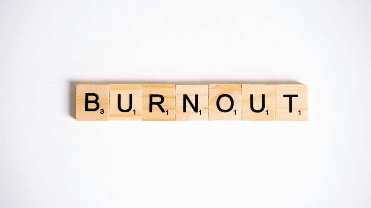 Conceptual image of 'Burnout' spelled with Scrabble tiles on a white background.