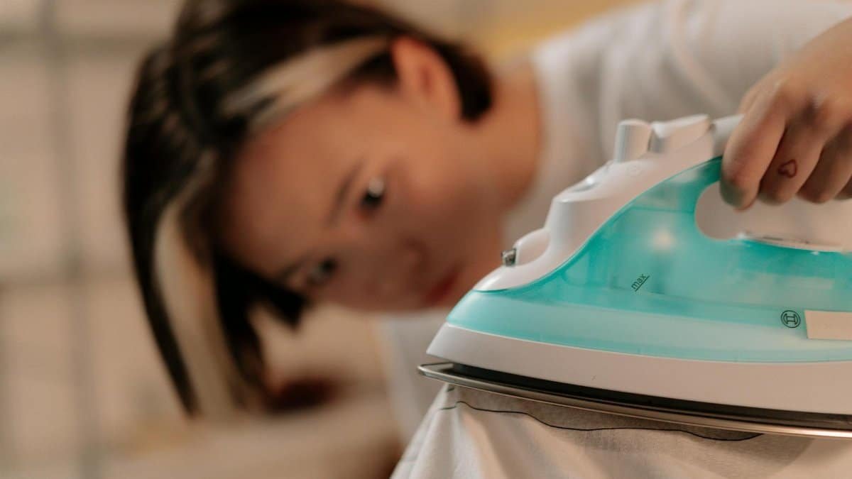 Focused woman ironing clothes at home, highlighting concentration and domestic tasks.