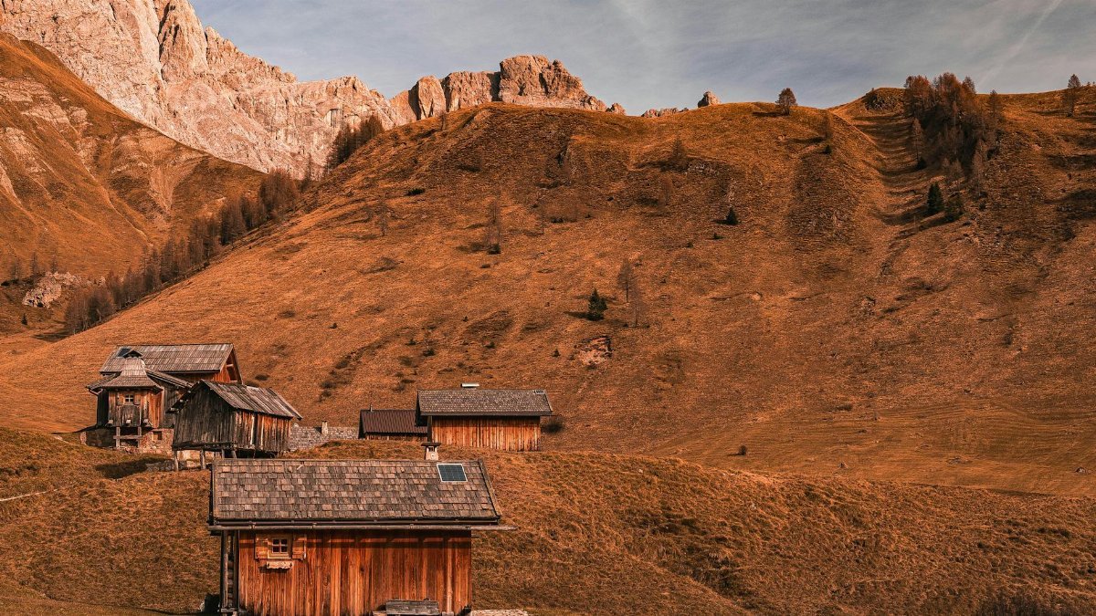 Charming wooden cabins nestled in a serene mountain landscape during fall. Ideal for nature retreats.