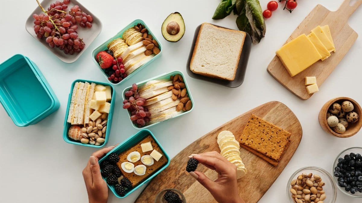 Top view of fresh and nutritious meal preparation with various fruits, nuts, and cheeses.