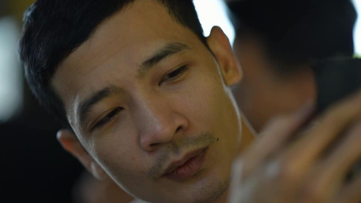 A focused man engaging with his smartphone in a casual indoor setting.