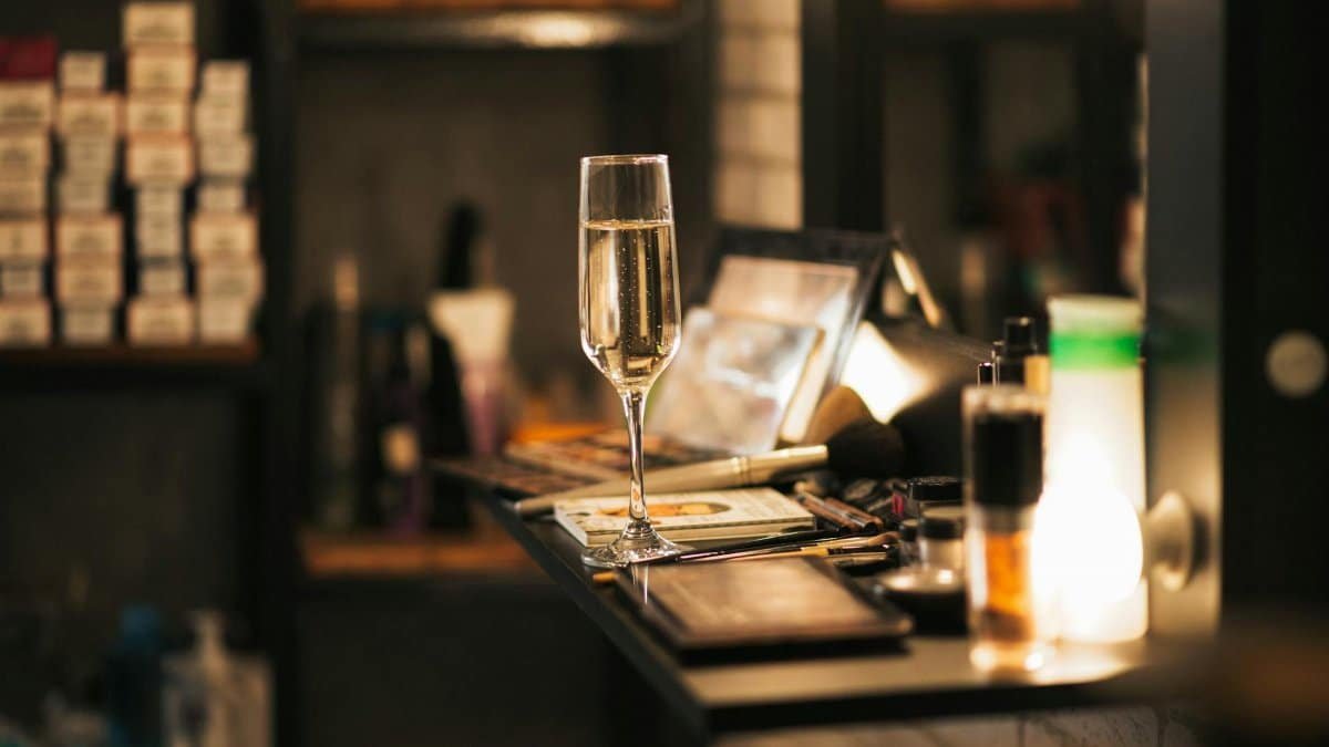 A champagne glass on a vanity surrounded by beauty products, exuding luxury and elegance.