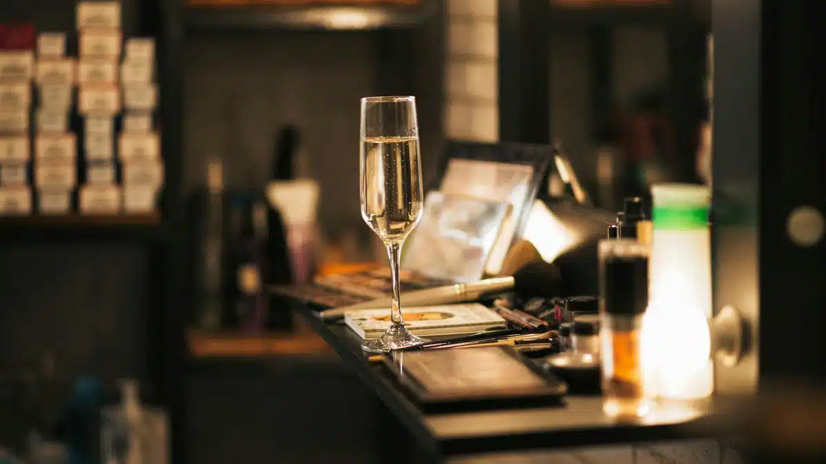 A champagne glass on a vanity surrounded by beauty products, exuding luxury and elegance.