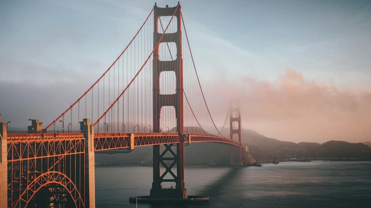 Golden Gate Bridge shrouded in fog during sunset, San Francisco.