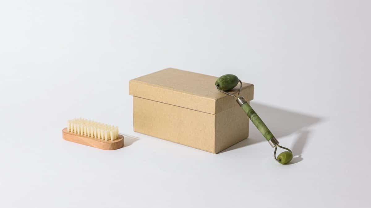 A jade roller and brush displayed with a simple box on a white background.