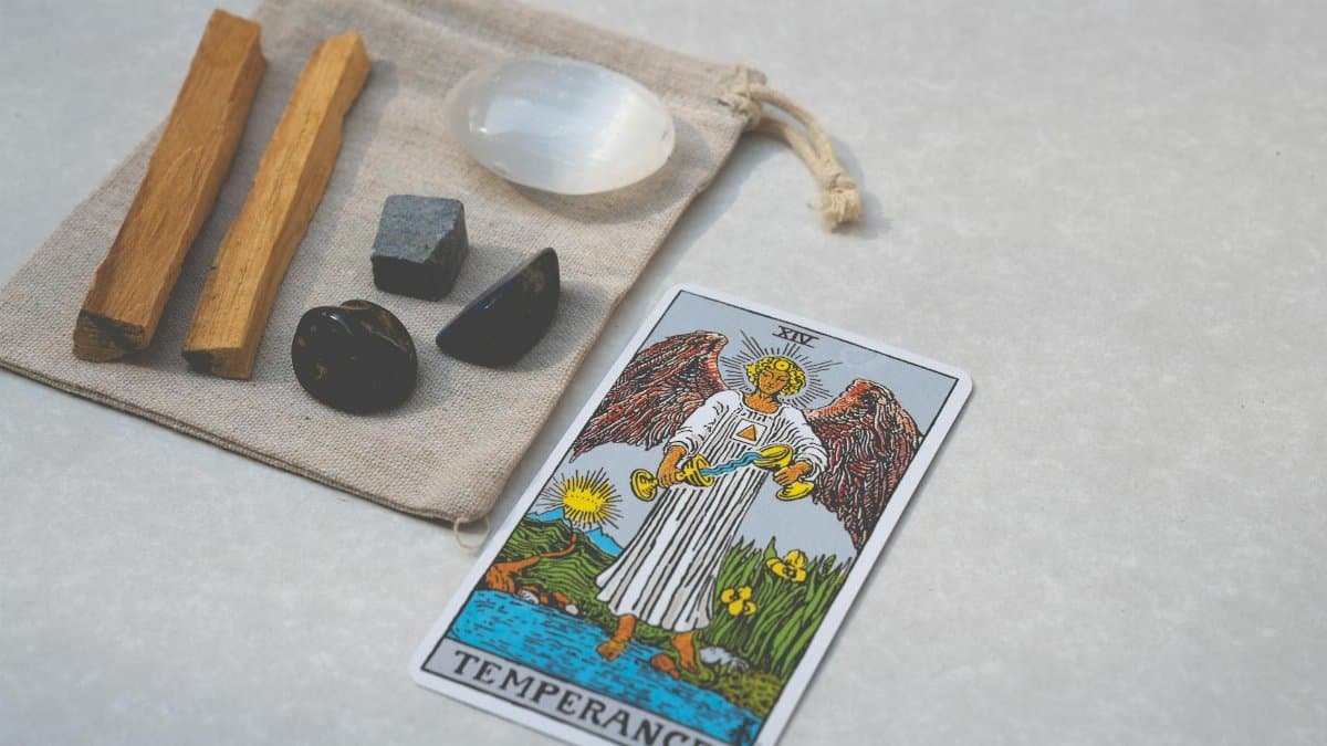 Temperance tarot card with healing crystals and Palo Santo on white background. Perfect for spirituality themes.