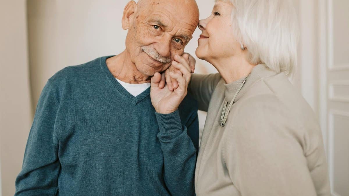 A heartwarming portrait of a senior couple expressing affection indoors, symbolizing love and happiness.