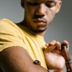 A man faces his fear by holding a snake, symbolizing courage and personal growth.