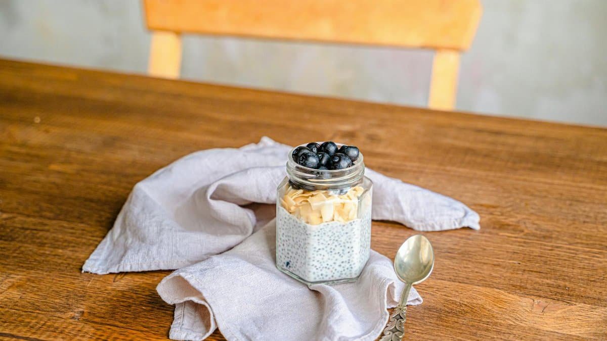 Healthy chia pudding with blueberries and coconut on a rustic wooden table. Perfect for breakfast.