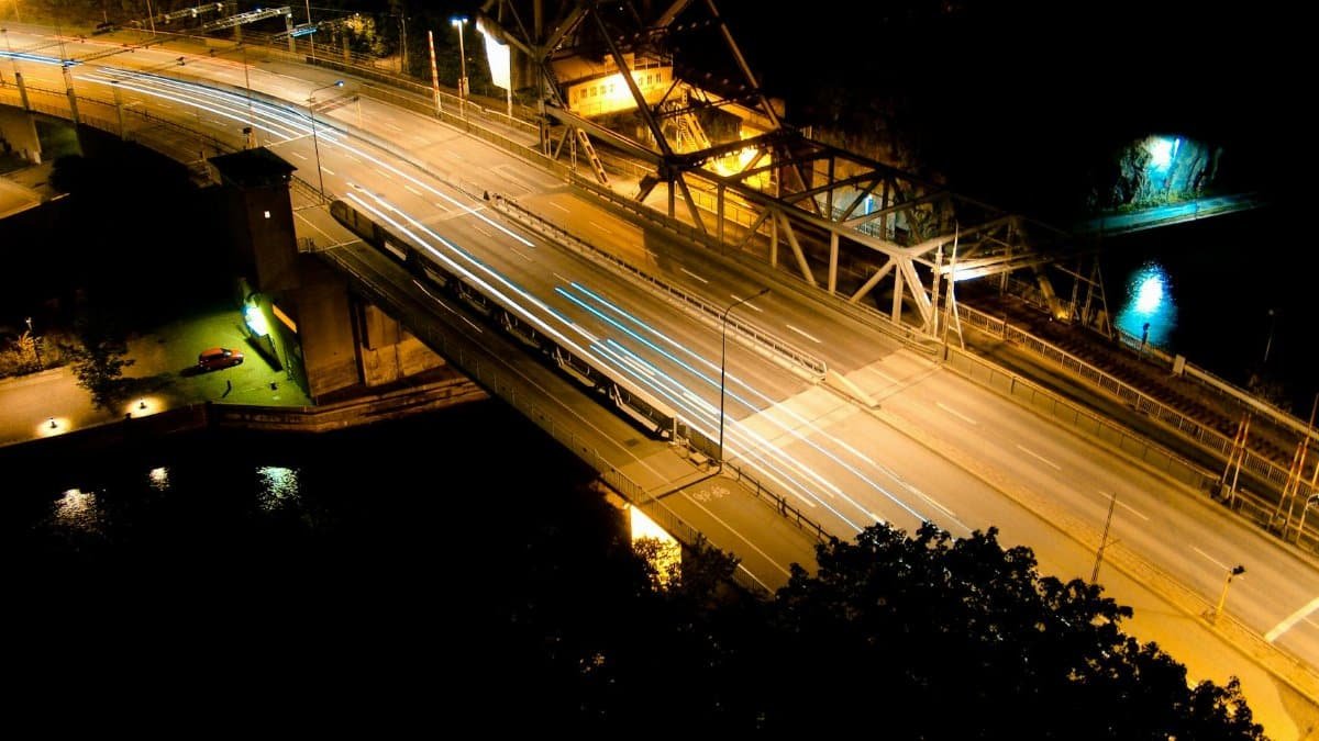 Aerial long exposure of a bridge in Norrmalm, Sweden, showcasing light trails and urban nightlights.