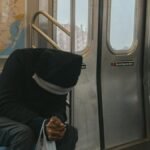 A lone passenger sitting in a New York City subway train, evokes feelings of solitude and reflection.