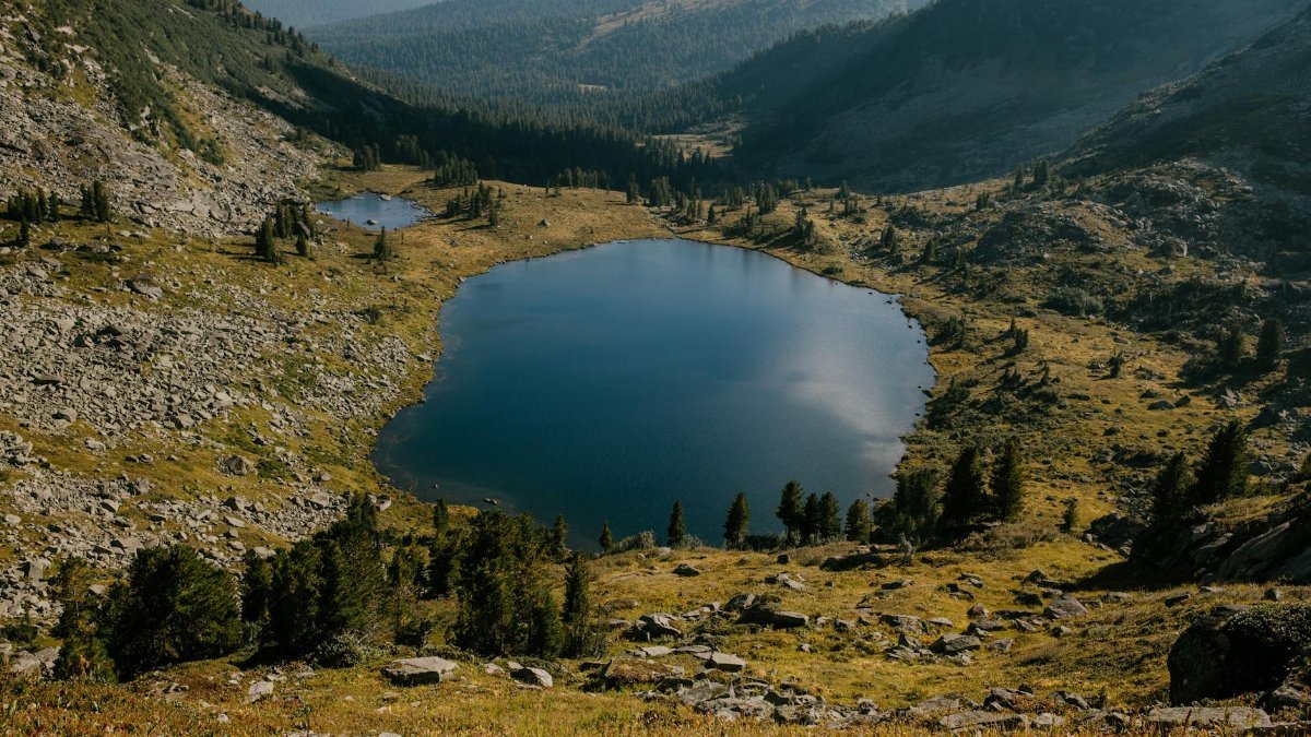 Tranquil view of a pristine mountain lake surrounded by hills in Khakassia, Russia.