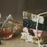 A stack of rustic handmade soap bars with natural ingredients and honey in a cozy setting.