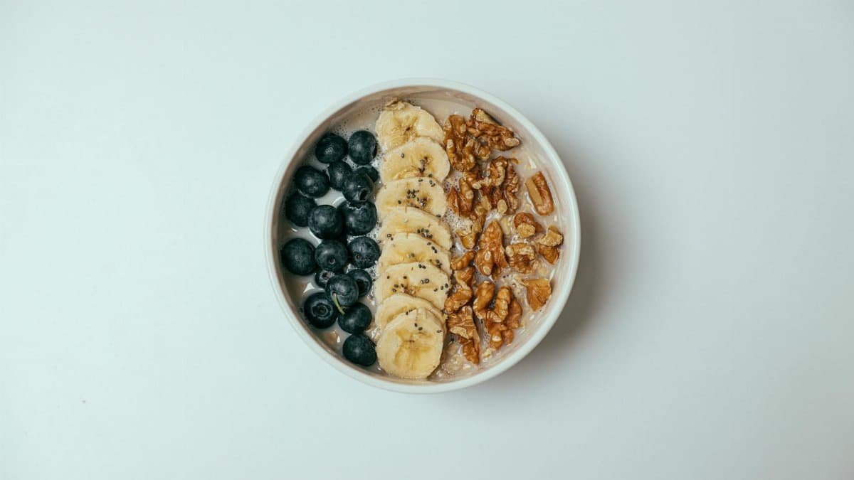 Delicious oatmeal bowl topped with blueberries, bananas, and walnuts.