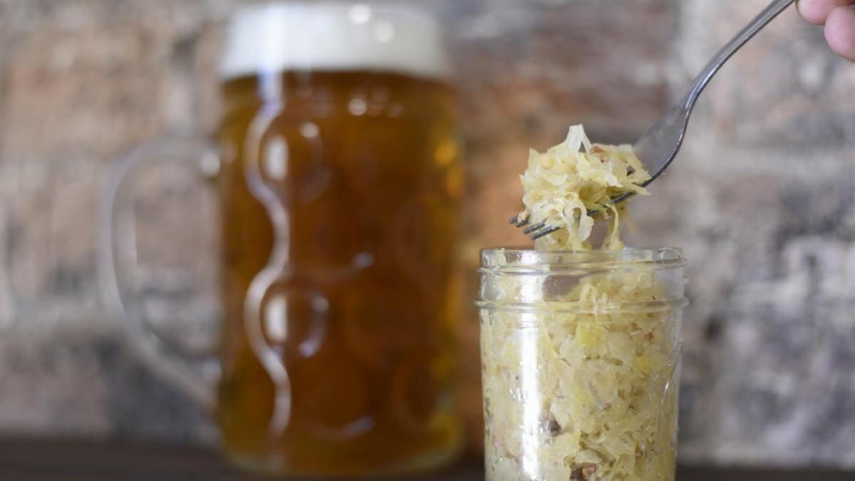 A rustic setting featuring a frothy beer mug and sauerkraut in a jar, perfect for pub themes.