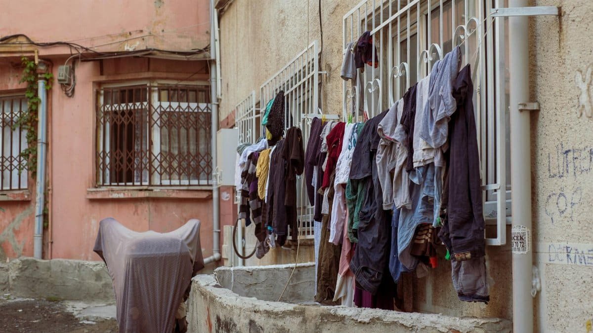 Clothes hang drying on a line in a rustic urban alley, showcasing daily life.