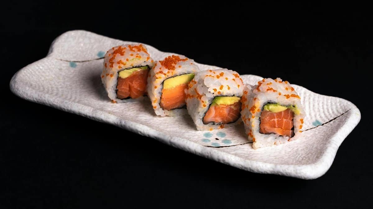 Tasty salmon and avocado sushi rolls presented on a stylish ceramic plate.