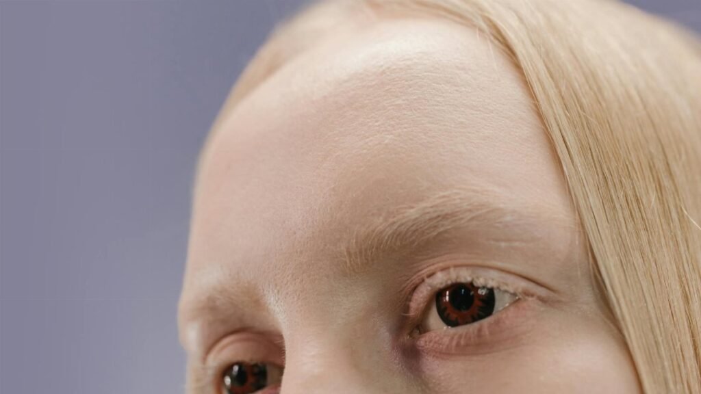 Detailed close-up of a blonde woman's eyes with a neutral background.