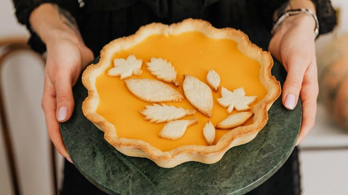 A delightful homemade pumpkin pie with decorative leaf shapes, perfect for autumn celebrations.