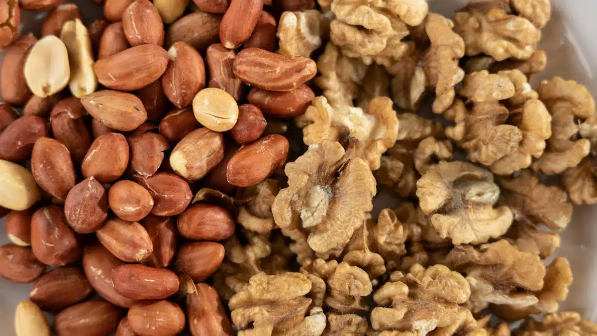 A detailed view of a healthy mix of raw peanuts and walnuts, highlighting texture and variety.