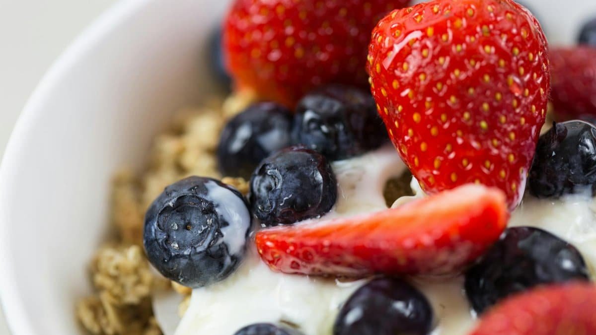 Close-up of fresh blueberries and strawberries on yogurt with granola.