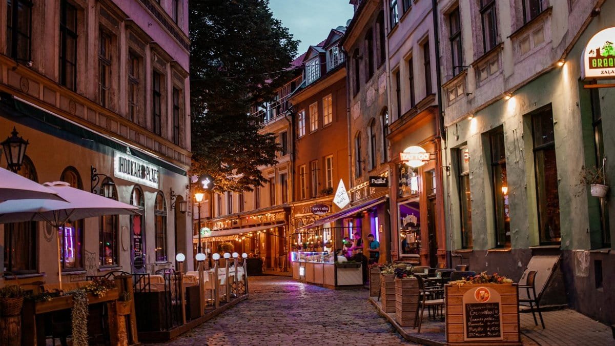 Idyllic evening scene of a cobblestone street with cozy shops and cafes in Old Town Riga.