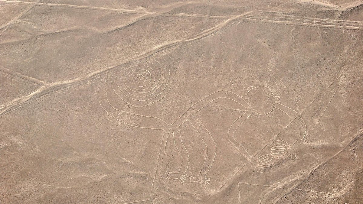 A stunning aerial capture of the iconic Nazca Lines, including the spiral and monkey figures, in Peru's desert landscape.