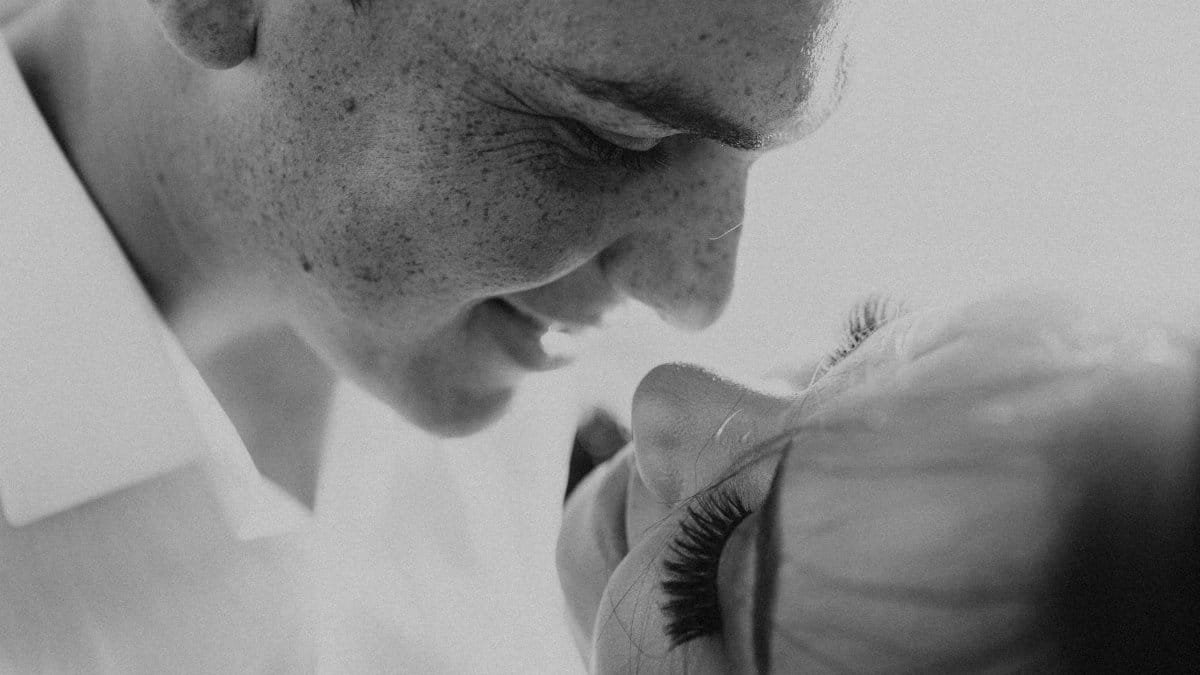 Close-up black and white portrait of a loving couple smiling at each other.