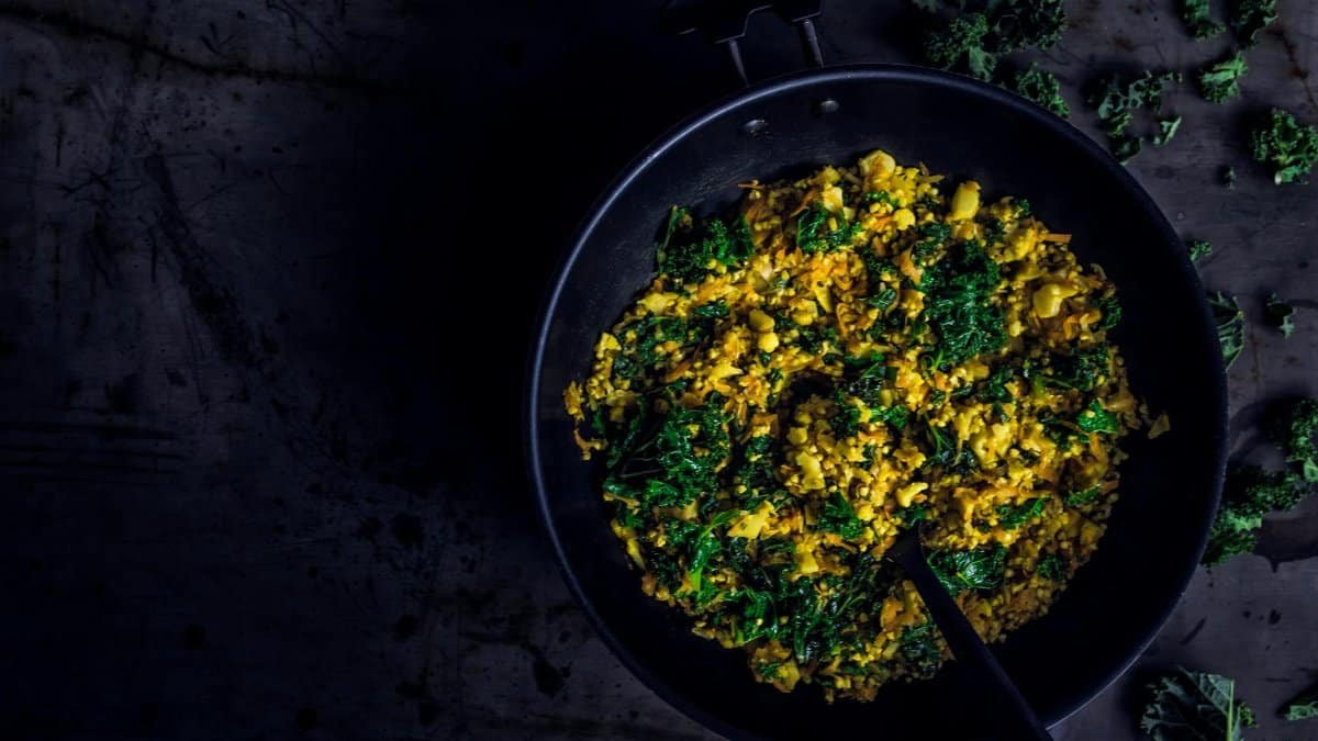 A vibrant and healthy kale stir-fry dish in a frying pan with bold colors and textures.