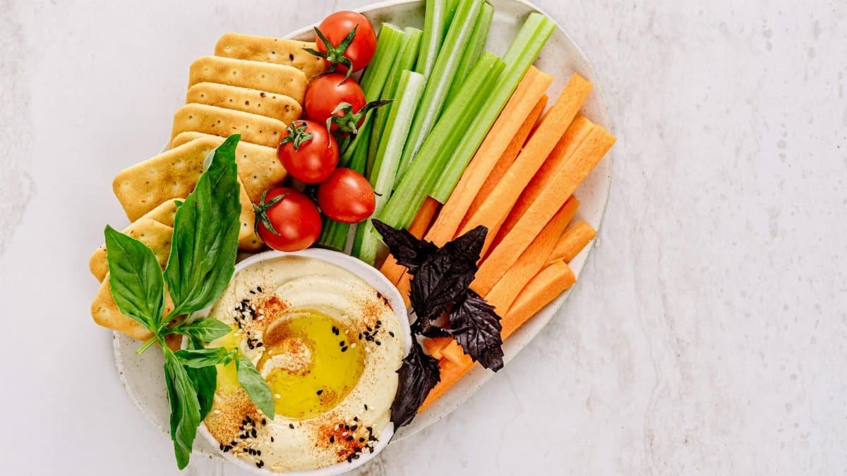 Top view of a delicious vegetable platter with hummus, ideal for healthy snacking.