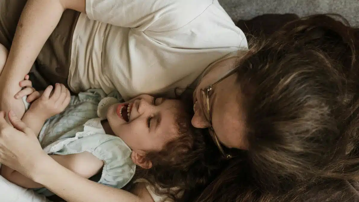 A loving mother embracing her laughing daughter, capturing a moment of joy and togetherness.