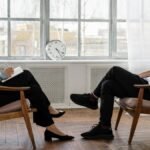A therapist engaging in a counseling session with a male patient to support mental health.